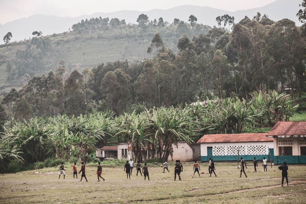 Children playing soccer in a rural village setting
