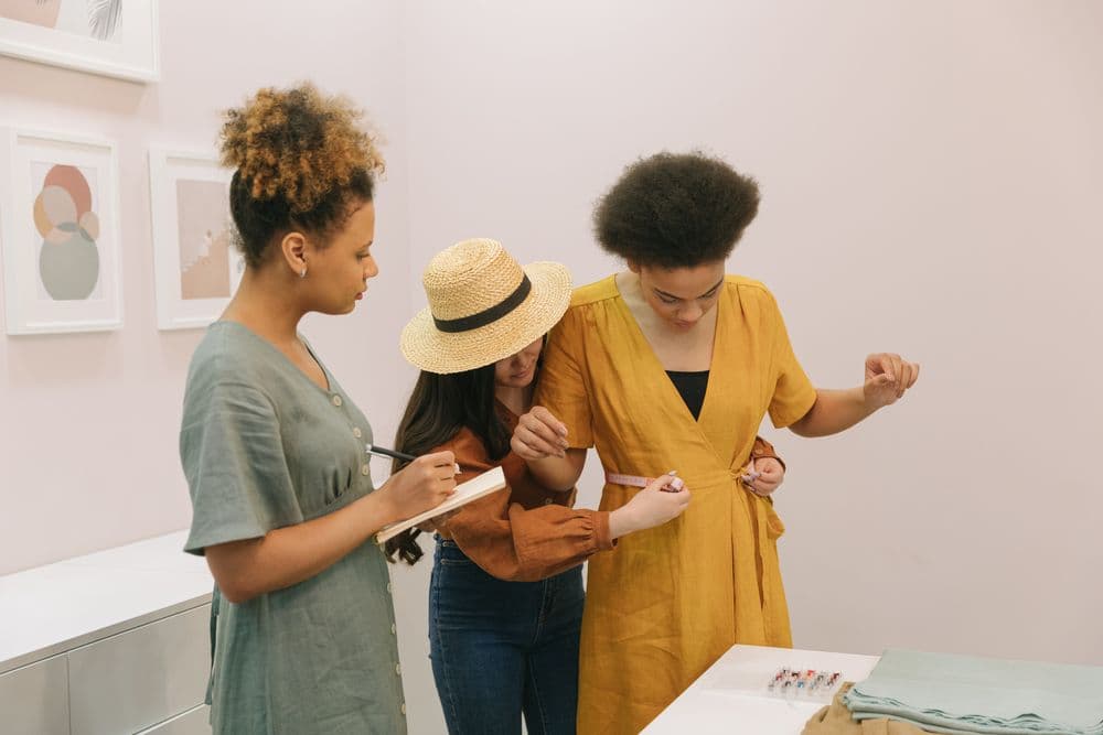 Women collaborating on dress measurements