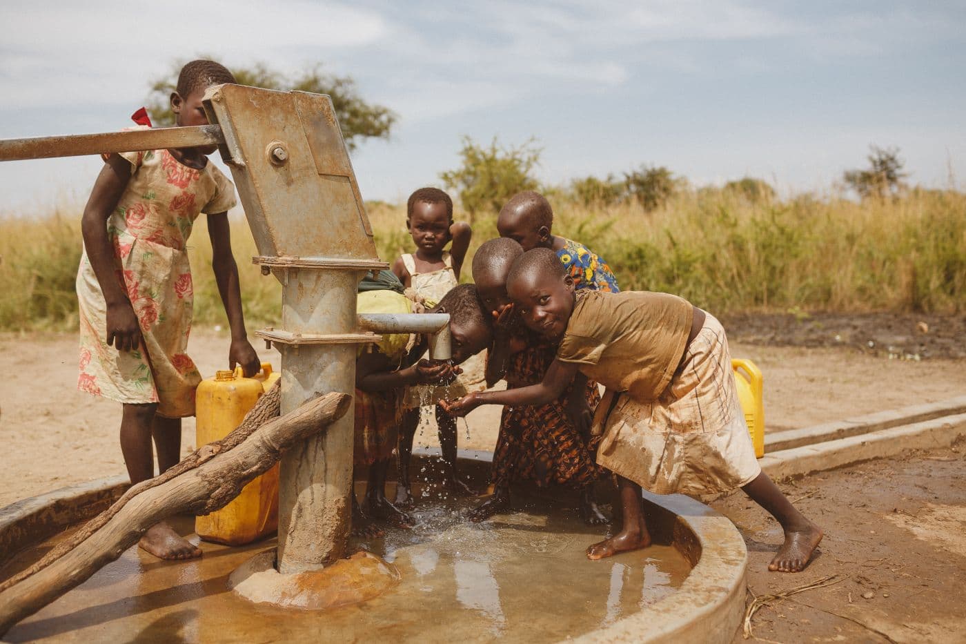 Children gathering clean water from a community well in Uganda