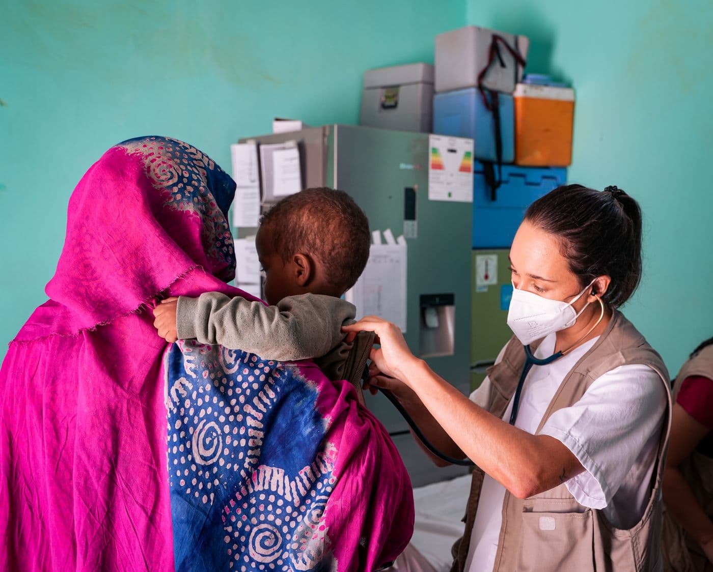 A community health worker attending to a child at a local clinic