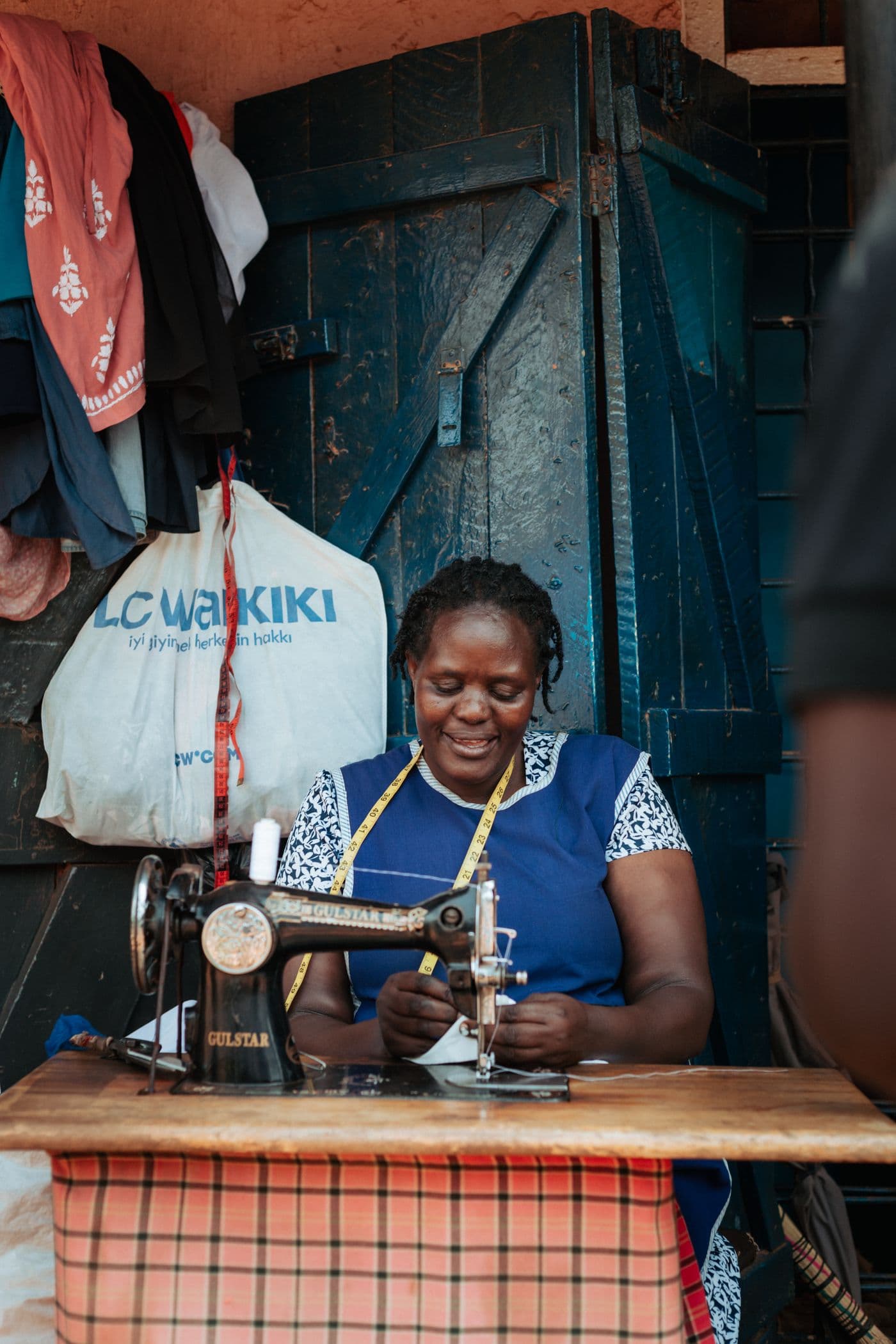 A smiling seamstress at a vintage sewing machine