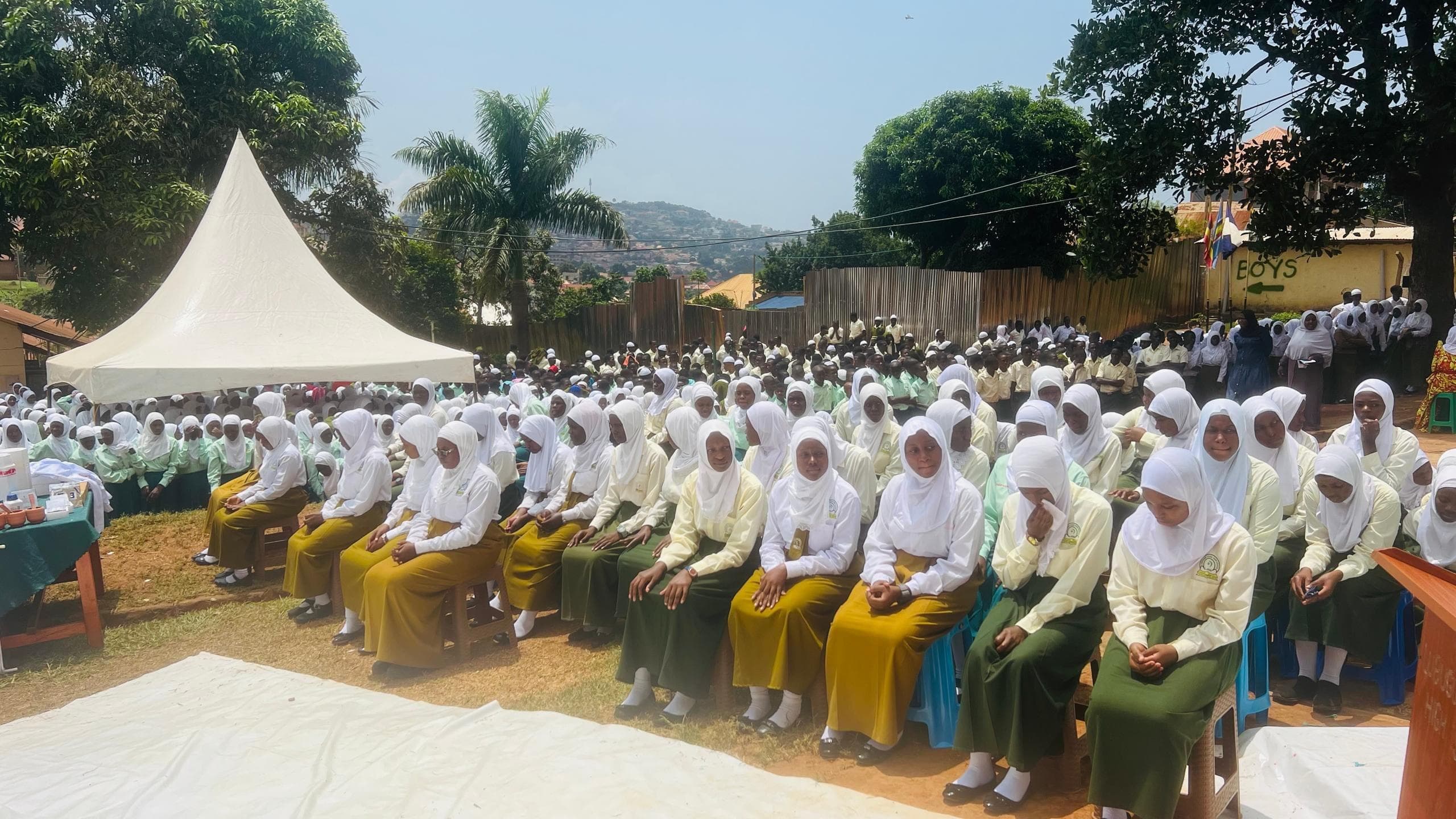 Rows of students seated together at an outdoor school assembly